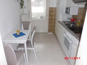 威廉港Apartment Zur Kogge的小厨房配有白色的桌子和椅子
