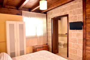 梅萨涅B&B Villa Anastasia Club的一间带石墙的卧室和一间带卫生间的浴室