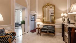 佛罗伦萨拉福尔泰莎酒店的客厅配有两把椅子和镜子