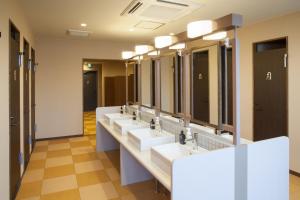 金泽日本金泽胶囊宾馆的浴室里一排带镜子的盥洗盆