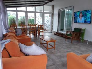 波多诺伏巴罗萨公寓的客厅配有橙色沙发、桌子和椅子