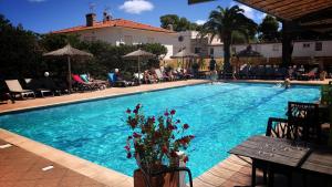 鲁西隆地区卡内阿奎瑞斯酒店的游泳池周围有人坐在椅子上