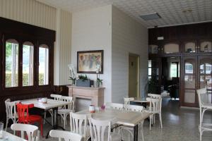 蒙多涅多Hotel Montero的餐厅设有桌子和白色的椅子以及窗户。