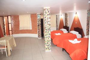 卡哈马卡Hotel Los Gladiolos的酒店客房设有两张床和一张桌子。