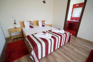 莫伊塞Casa Bunicii的一间卧室配有一张带红白条纹毯子的床