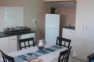 Sea ViewOcean Sunset的厨房配有带白色冰箱的桌子