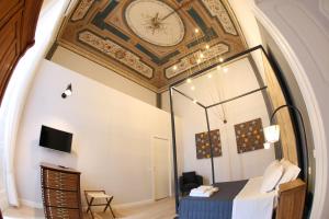 那不勒斯The Dante House by House In Naples的一间天花板上设有时钟的房间和一张床