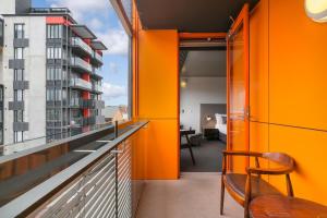 阿德莱德The Soho Hotel的橙色客房设有带桌椅的阳台。