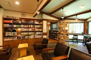 木曾町宿驹汤日式旅馆的图书馆配有桌椅和书架