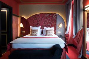巴黎快乐文化纳比酒店的一间卧室配有一张大床和红色床头板