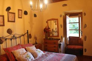 阿古洛Casa Rural Las Rosas的一间卧室配有一张床、梳妆台和镜子
