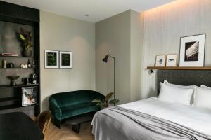 巴黎国立工艺学院酒店的一间卧室配有一张床和一把绿色椅子