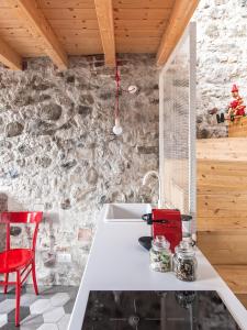 萨尼科拉卡萨德拉齐亚酒店的厨房配有白色水槽和红色椅子