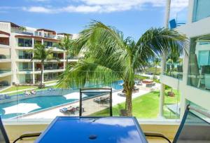普拉亚卡门The Elements Oceanfront & Beachside Condo Hotel的一张桌子上的笔记本电脑,享有游泳池的景色
