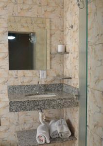 巴乌鲁Telma Hotel的浴室配有盥洗盆、镜子和毛巾
