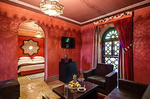 非斯奥梅亚宫套房Spa酒店的客厅设有红色的墙壁和一张带窗户的床