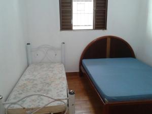 卡拉瓜塔图巴Casa em Caraguatatuba的一间卧室设有两张床和窗户。