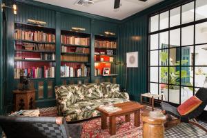 巴拿马城美洲贸易酒店的客厅设有绿色的墙壁、沙发和书架
