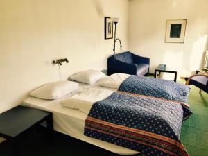 温斯特拉Sødorp Gjestgivergård Motell的一间卧室配有两张床和一张蓝色椅子