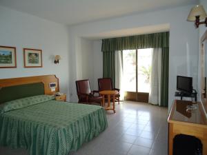 拉拉维塔Hotel las Conchas的酒店客房,配有床和电视