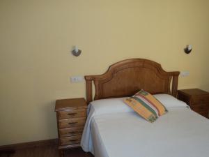 坎加斯德尔纳尔塞亚Apartamentos Casa Rosendo的一间卧室配有一张带木制床头板的床和2个床头柜。