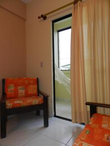 纳塔尔艾颇雷蒂亚公寓酒店的一间带椅子和滑动玻璃门的房间