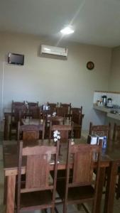 阿拉瓜伊纳Hotel Boiadeiro的一间带桌子和木椅的用餐室