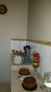 阿拉瓜伊纳Hotel Boiadeiro的厨房柜台,提供两块蛋糕和一碗水果