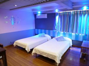 香港Espace Elastique B&B with contactless check-in的蓝色墙壁客房的两张床