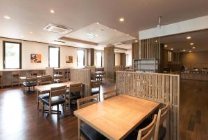 Yōkaichi东近江八日市站前酒店的用餐室配有木桌和椅子