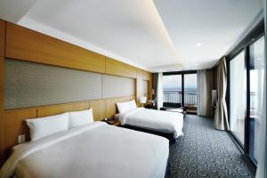 束草市Ramada by Wyndham Gangwon Sokcho的酒店客房设有两张床和大窗户。