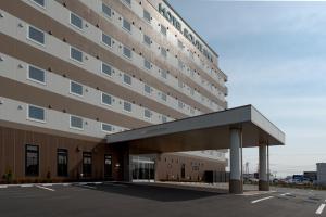 Kashima鹿岛路酒店的一座大型建筑,前面设有停车场