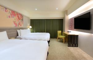 台中市台中爱丽丝国际大饭店的酒店客房设有两张床和电视。