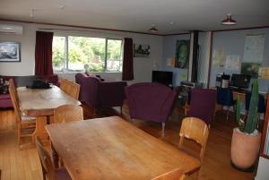 图朗伊Riverstone Lodge的一间带桌子和紫色椅子的用餐室