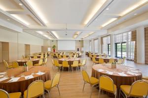 萨龙诺米兰星际大酒店的大房间设有桌椅和白板