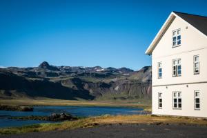 Búðir布迪尔酒店的享有河流和山脉美景的白色房屋