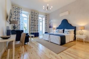 波尔蒂芒Villa Rio Guest House Suites的一间卧室配有蓝色的床和桌椅