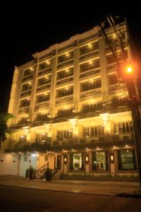 马尼拉Herald Suites Polaris的一座白色的大建筑,晚上有灯