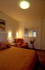 卡托利卡Residence Darsena的一间卧室配有一张床、一张沙发和一把椅子