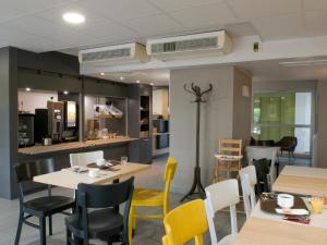 隆戈B&B HOTEL Amiens的一间带桌椅的餐厅和一间厨房
