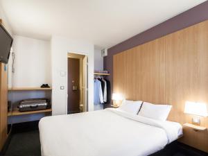隆戈B&B HOTEL Amiens的卧室配有一张白色大床和电视。