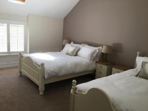 兰戈伦Riverside Suites Llangollen的一间卧室设有两张床和窗户。