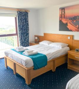 特雷杜尔海滩汽车旅馆的一间卧室配有一张床,上面有两条毛巾