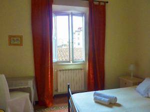 佛罗伦萨塔贝纳克罗住宿加早餐旅馆的一间卧室配有床和红色窗帘的窗户