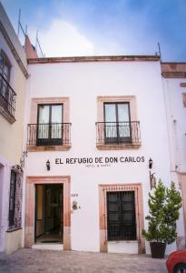 萨卡特卡斯Hotel y Suites El Refugio de Don Carlos的白色的建筑,带有“卡托词”