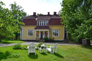 罗威萨鲍姆加特纳别墅的院子里的黄色房子,配有两把椅子和一张桌子
