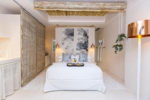 圣安娜纳克索斯Sea Nymphs Suites的卧室配有白色的床和大镜子