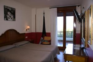 圣塞瓦斯蒂安乐库埃德酒店的一间卧室设有一张床和一个滑动玻璃门
