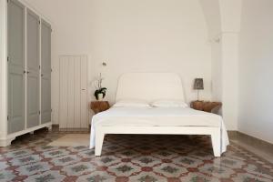 科尔萨诺Il Pergoletto的卧室配有白色的床和地毯。