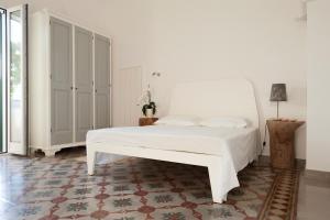 科尔萨诺Il Pergoletto的卧室配有白色的床和地毯。